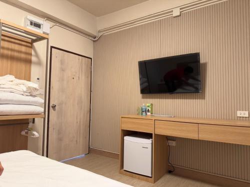 Schlafzimmer mit einem Schreibtisch und einem TV an der Wand in der Unterkunft Apartment Near Big Buddha in Bangkok Yai