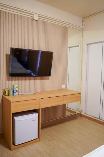a room with a desk with a television on a wall at Apartment Near Big Buddha in Bangkok Yai