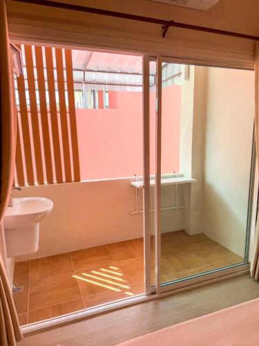 a bathroom with a toilet and a glass door at Apartment Near Big Buddha in Bangkok Yai