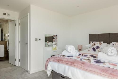 a bedroom with a large bed with towels on it at Beachcliff - On the Seafront with Two Balconies in Bournemouth