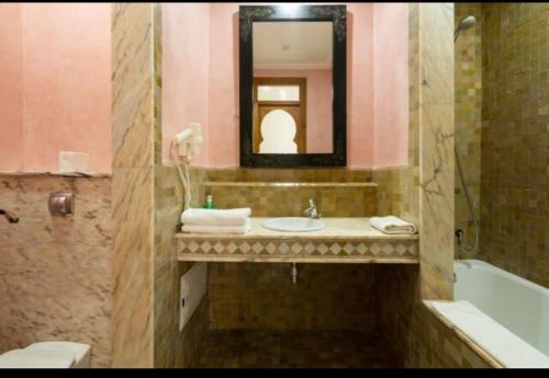 a bathroom with a sink and a tub and a mirror at Palmeraie Village 2 in Marrakesh