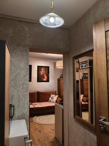 a living room with a couch and a mirror at Apartament Królewskie Pawie in Sandomierz