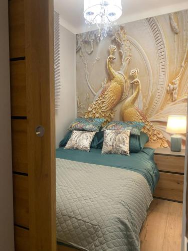 a bedroom with a bed with two seahorses on the wall at Apartament Królewskie Pawie in Sandomierz