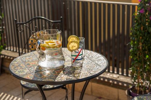 a glass table with a glass pitcher and lemon slices on it at Consi's House - ItalyWeGo in Torgiano