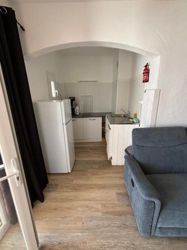 a living room with a couch and a kitchen at Résidence Punta paliagi in Calcatoggio