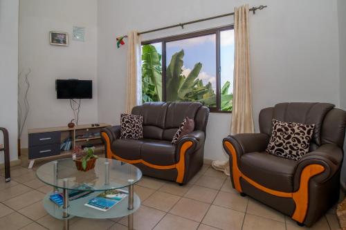 a living room with two chairs and a glass table at Soleil Levant in Victoria