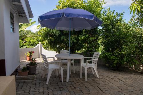 a table and chairs with a blue umbrella at Soleil Levant in Victoria