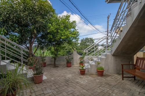 a patio with potted plants and a staircase at Soleil Levant in Victoria