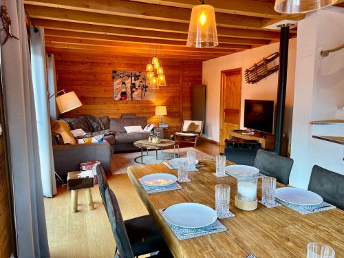 un salon avec une table avec des chaises et un canapé dans l'établissement Chalet Serre Chevalier 160m2 9 pers - Sauna, 5 chambres, à Saint-Chaffrey
