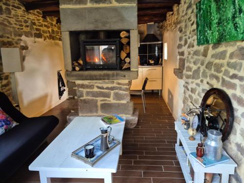 - un salon avec deux tables et une cheminée dans l'établissement L'herbe est plus verte, à Beynat