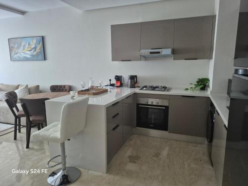 a white kitchen with a counter and a table at aeroperla 11 aeroprt casa blanca in Nouaseur