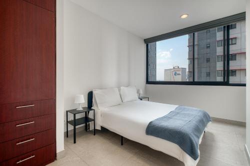 a bedroom with a bed and a large window at Polanco Boutique Living - Junto a Embajada USA in Mexico City