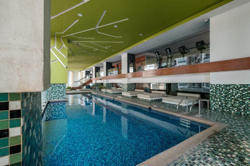 a swimming pool with benches and tables in a building at Polanco Boutique Living - Junto a Embajada USA in Mexico City