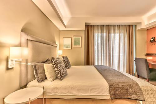 a bedroom with a large bed and a desk at WINK Aparthotel Foreshore in Cape Town