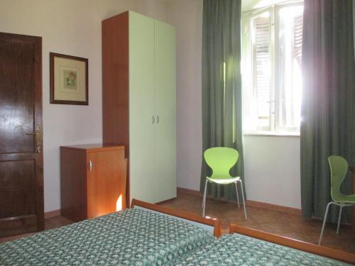 a bedroom with a bed and a chair and a window at Affittacamere Villa Delia in Lucca