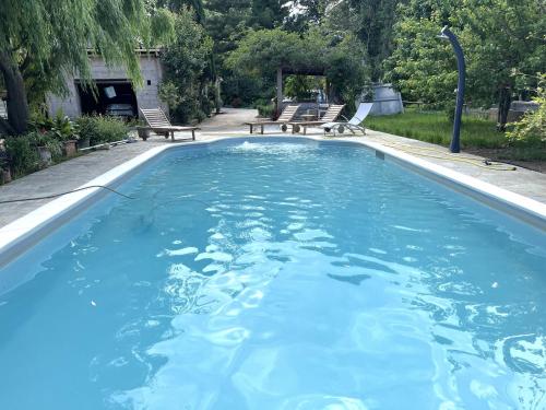 une grande piscine avec de l'eau bleue dans une cour dans l'établissement FURIANI Appartement avec Piscine dans Villa, à Furiani