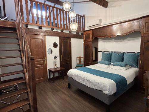- une chambre avec un lit doté d'oreillers bleus et un escalier dans l'établissement Domaine de Hurlevent, à Montgaillard-Lauragais