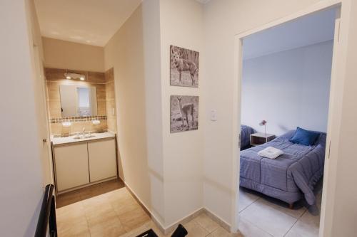 a bedroom with a bed and a bathroom with a sink at Complejo Coirón in San Rafael