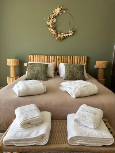 a bed with towels on it with a wreath on the wall at La Maison d'Ambrine - Villa Grignan in Grignan