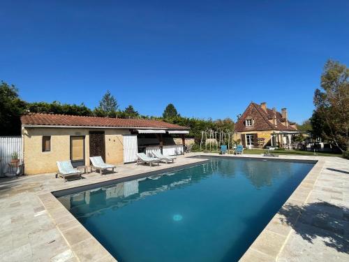 une piscine avec des chaises et une maison dans l'établissement Appel d'Air Authentique longère rénovée, à Meyrals