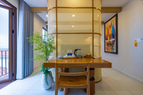 a room with a wooden table and a large window at Lotus Home Corner & Rooftop in Phu Quoc