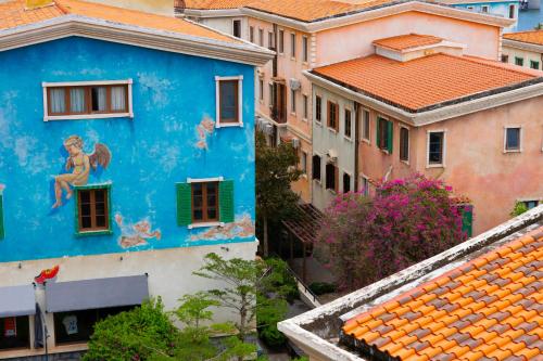 a blue building with a painting on the side of it at Lotus Home Corner & Rooftop in Phu Quoc