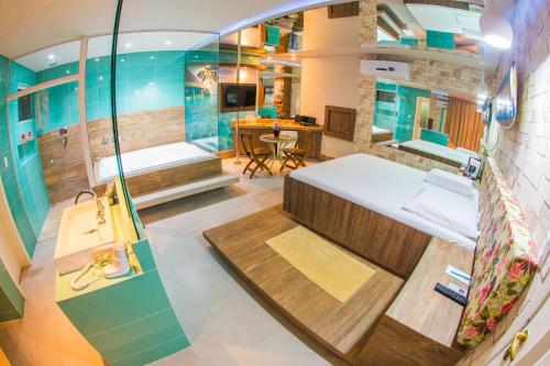 a small room with a bed and a shower at Ragam Motel Empreendimentos Hoteleiros in Ponta Grossa