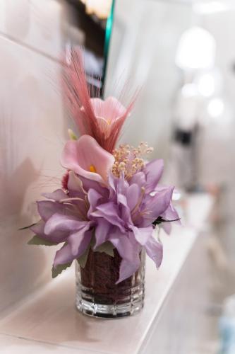 a vase filled with purple flowers sitting on a counter at NEW Gästehaus Flora,Kitchen,TV,Free Parking,near Europa Park and Strasbourg in Hohberg