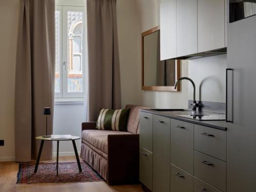 a living room with a couch and a kitchen at Residenza Manci 44 by Hotel America in Trento