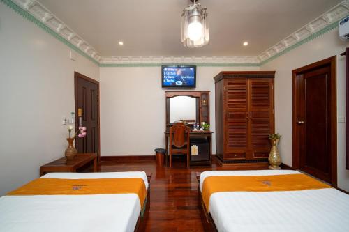a hotel room with two beds and a television at Hello Cambodia Hotel in Phumi Ta Phul