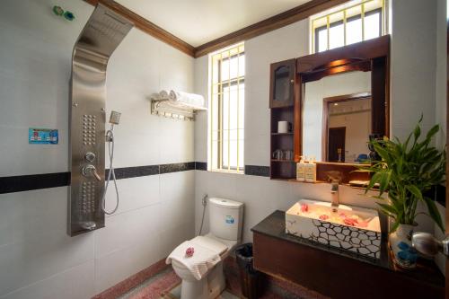 a bathroom with a toilet and a sink and a mirror at Hello Cambodia Hotel in Phumi Ta Phul