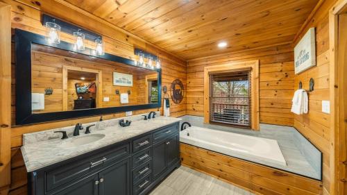 a log cabin bathroom with a tub and a sink at Cozy Black Bear Cabin porch swing & stunning views in Sevierville