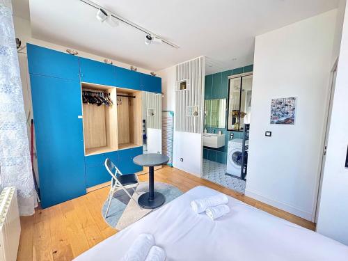 - une chambre avec un lit blanc et un mur bleu dans l'établissement Charmant appartement en plein cœur du centre-ville, à Amiens