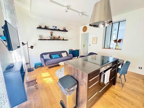 une cuisine et un salon avec un canapé et une table dans l'établissement Charmant appartement en plein cœur du centre-ville, à Amiens