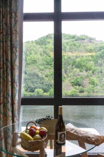a bottle of wine and a basket of fruit in front of a window at Treixadura in Pincelo