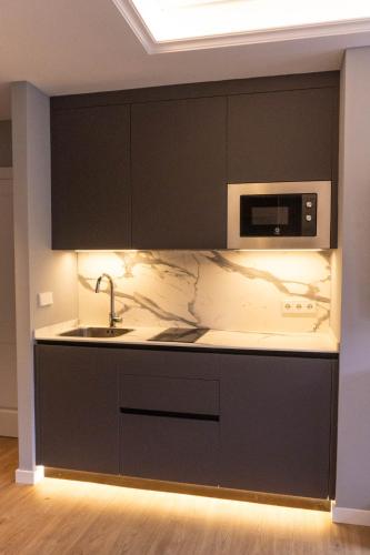 a kitchen with a sink and a microwave at Treixadura in Pincelo