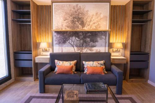 a living room with a blue couch with orange pillows at Treixadura in Pincelo