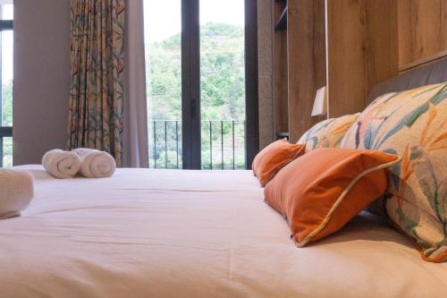 a bedroom with a bed with pillows and a window at Treixadura in Pincelo