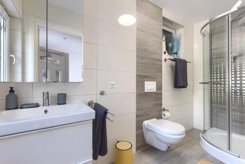 a white bathroom with a toilet and a sink at Villa Sonja in Medulin