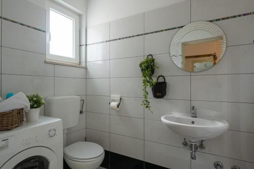 a bathroom with a toilet and a sink and a mirror at Villa Laura in Krnica