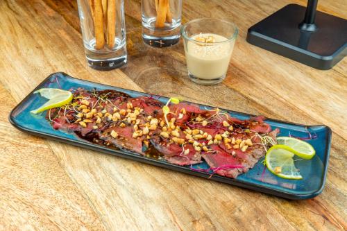 a plate of food on a table with a drink at Logis Hôtel Vannes Nord Le Clos Des Hortensias in Locqueltas