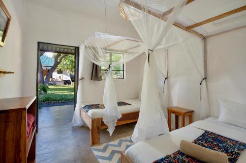 a bedroom with two beds with mosquito nets at Kamunjila Lodge in Livingstone