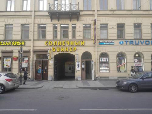 een gebouw in een straat waar auto's voor geparkeerd staan bij Simple Babushka House in Sint-Petersburg