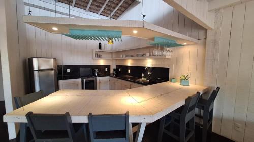 a kitchen with a large wooden table and chairs at As Palhas in Amontada