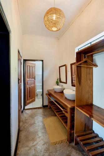 a bathroom with two sinks on a counter and a mirror at Kamunjila Lodge in Livingstone