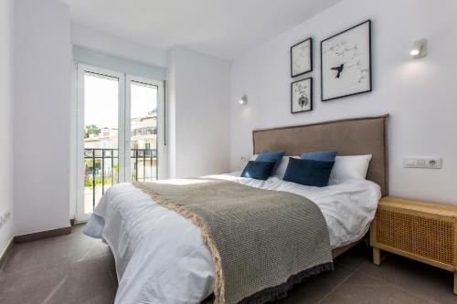 デニアにあるLuxury Apartment Denia with Pool & Montgó Viewの青い枕が付いた大きなベッドのある寝室