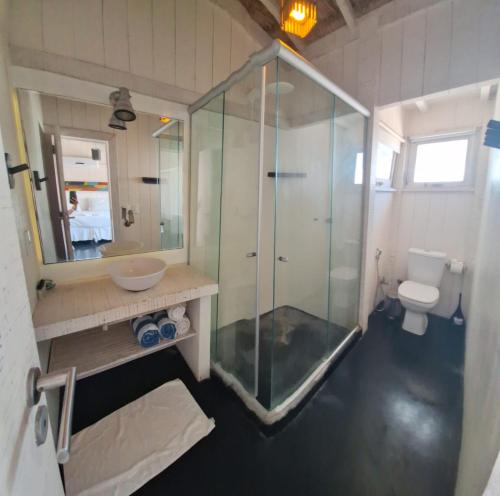 a bathroom with a shower and a sink and a toilet at As Palhas in Icaraí