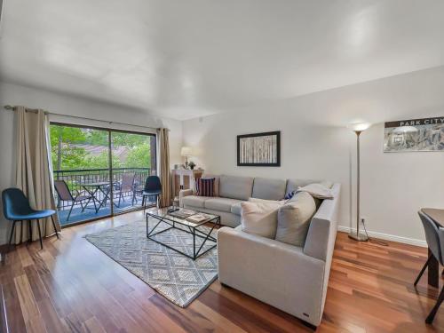 ein Wohnzimmer mit Sofa und Tisch in der Unterkunft 129 Park Station Escape! Cozy Condo with Pool Hot Tub! Walking Distance to Main Street Town Lift! by SkyRun Park City in Park City