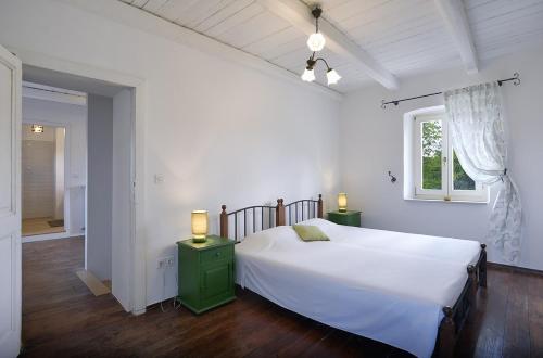 a bedroom with a large white bed and a window at Villa Krase in Svetvinčenat