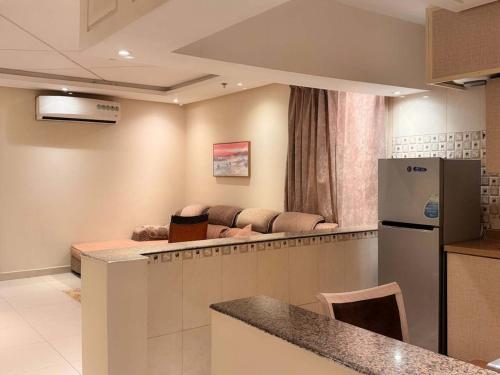 a living room with a couch and a kitchen at فندق اكارم اشبيليا - Akarem ishbilia Hotel in Riyadh